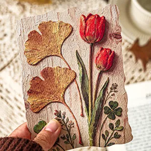 Vintage 3D-Prägepapier für Scrapbooking mit Tulpen- und Ginkgomotiven in der Hand