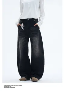 Close-up of washed black curved jeans with 8-ball metal chain and vintage texture