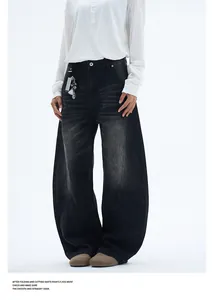 Close-up of vintage washed dark gray baggy jeans with deconstructed拼接and cat-whisker fades