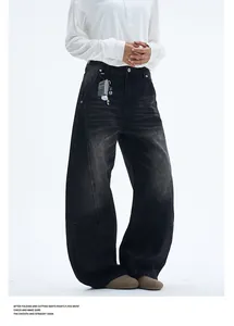 Detail of washed black wide-leg jeans featuring structural stitching and raw denim texture