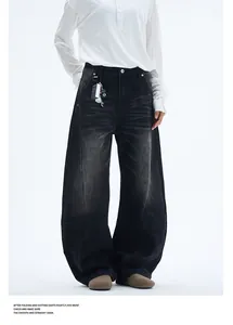 Close-up of washed charcoal denim texture and relaxed wide-leg cut on retro jeans
