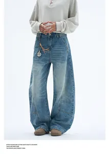 Close-up detail of retro washed blue denim pants with unique curved seam stitching
