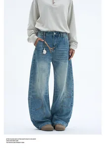 Close-up of washed blue wide-leg jeans featuring vintage whiskers and curved seam construction