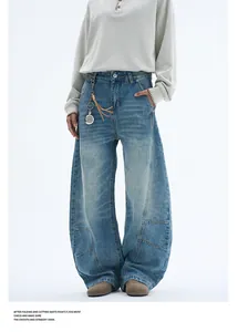 Detail of light blue washed denim with curved seams and leather fringe charm decoration