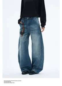 Gros plan d'un jean bleu délavé rétro à jambes larges avec pendentif latéral et moustaches
