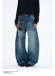 Gros plan d'un jean large bleu délavé vintage avec moustaches et coutures contrastées