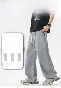 Dettaglio di jeans grigi da uomo larghi con coulisse bianca in vita e taglio dritto