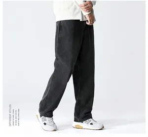 Detail of loose fit black washed denim jeans showing textured fabric and wide leg cut