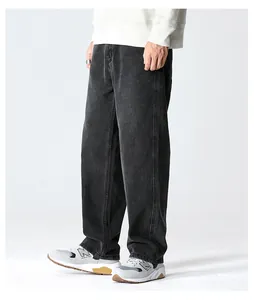 Macro shot of dark grey washed denim fabric texture and wide leg fit on male model