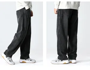 Detail view of charcoal grey washed denim jeans showing loose fit and fabric texture