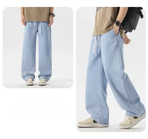 Dettaglio di jeans a gamba larga azzurri con coulisse regolabile in vita e vestibilità comoda
