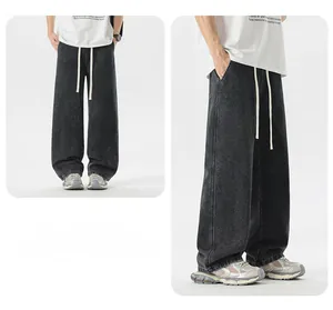 Dettaglio dei pantaloni in denim nero a gamba larga con coulisse bianca a contrasto