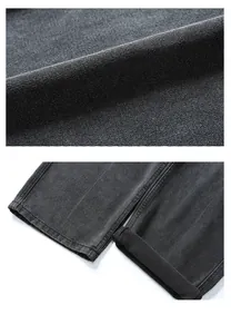 Detailed macro view of heavy black denim fabric texture and double-stitched hem finish