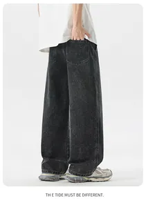 Dettaglio dei pantaloni in denim grigio scuro lavaggio acido con vestibilità ampia e tasca