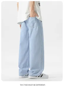 Dettaglio dei jeans azzurri a gamba larga con grandi tasche posteriori e cuciture
