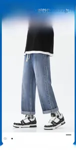 Détail de jean bleu clair à jambes larges avec coutures décoratives et ourlets repliés
