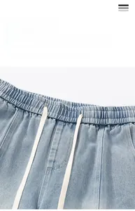 Detail of elastic waist and white drawstring on light blue gradient denim shorts