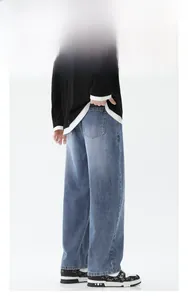 Détail du jean denim bleu délavé ample avec surpiqûres contrastées et poches arrière