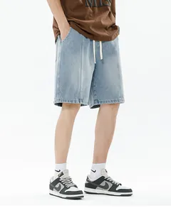 Detail of light blue denim shorts featuring a drawstring elastic waist and washed texture