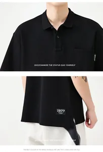 Détail du polo noir en coton avec poche poitrine et étiquette tissée 1977 sur le côté