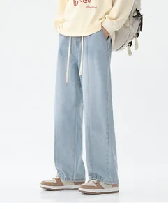 Détail des doubles surpiqûres contrastées sur un jean denim bleu clair à coupe décontractée