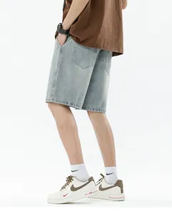 Detail view of baggy light blue denim shorts featuring rear pockets and clean stitching