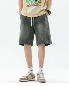 Detail of drawstring elastic waistband and vertical stitching on men's gray denim shorts
