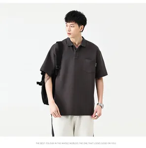 Détail d'un polo gris anthracite avec poche poitrine et étiquette tissée