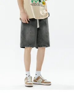 Detail view of washed black denim shorts featuring white drawstring and vertical pleat seams