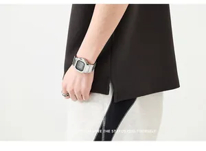 Détail de la fente latérale du polo noir et du short patchwork gris à couture blanche