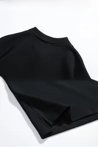 Détail d'un polo noir montrant le tissu piqué respirant et la fente latérale à l'ourlet