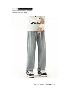 Detail of light blue washed straight leg jeans with drawstring waist and denim texture