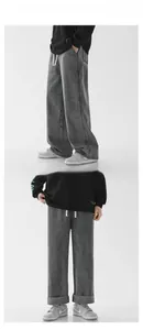 Detail view of dark grey wide-leg trousers with white drawstring and street style cut
