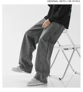 Detail shot of wide-leg gray denim pants featuring vertical side seam stitching and relaxed fit