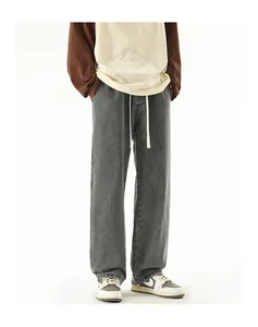 Detail view of washed dark grey loose jeans with elastic waist and cream drawstring