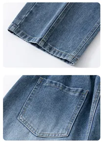Détail du jean denim bleu montrant l'ourlet, la poche arrière et la texture du tissu sergé