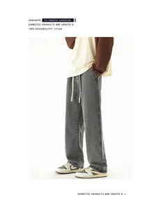Detail of grey wide-leg jeans featuring a vintage washed texture and cream drawstring waist