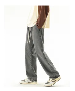 Detail of grey washed wide-leg jeans with contrast drawstring and straight fit design
