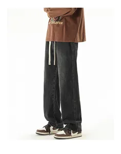 Close-up of charcoal gray wide-leg jeans with drawstring waist and vintage wash detail