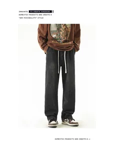 Detail of loose-fit washed grey jeans featuring elastic drawstring waist and vintage texture