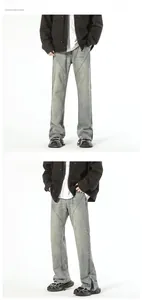 Detailed view of grey washed flared jeans with unique diagonal contrast stitching and side zippers