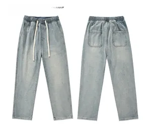 Detailed flat lay of light blue washed denim pants with elastic waist and white drawstrings