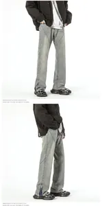 Detail view of washed grey jeans showing V-shaped stitching and hem zippers