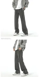 Detail of dark grey washed denim flare pants with zip leg opening and panel stitching