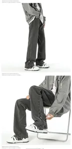 Detailed view of grey washed denim jeans with side zipper cuff and stitching details