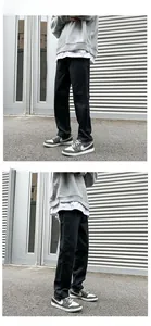 Men's black straight-leg jeans shown in a side-view pose against an industrial background