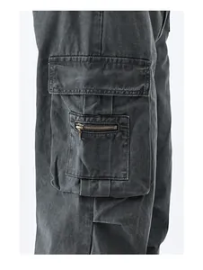 Detail of vintage washed black cargo pants featuring double side pockets and bronze zippers