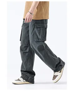 Detail view of charcoal grey cargo pants with side flap pockets and washed fabric texture