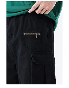 Detailed close-up of heavy cotton twill cargo pants with functional zipper pocket and flap