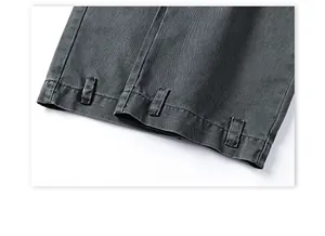 Detail of dark grey cargo pants cuff showing cotton twill texture and stitching